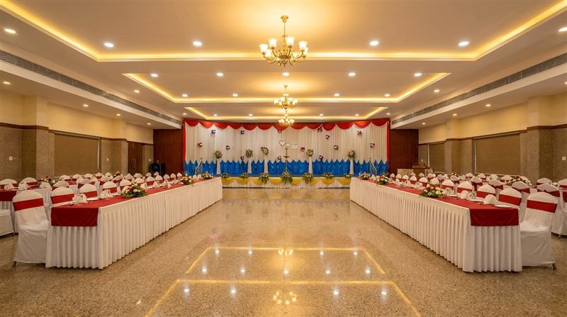 Formal dining setup with draped tables and chandeliers