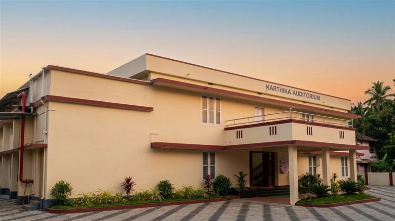 Auditorium exterior against a sunset sky