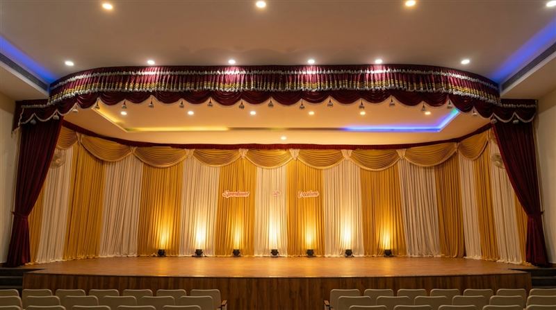 Wooden stage with gold and white curtains