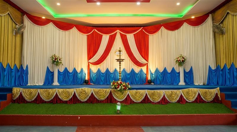 Stage with gold and white drapes and green turf